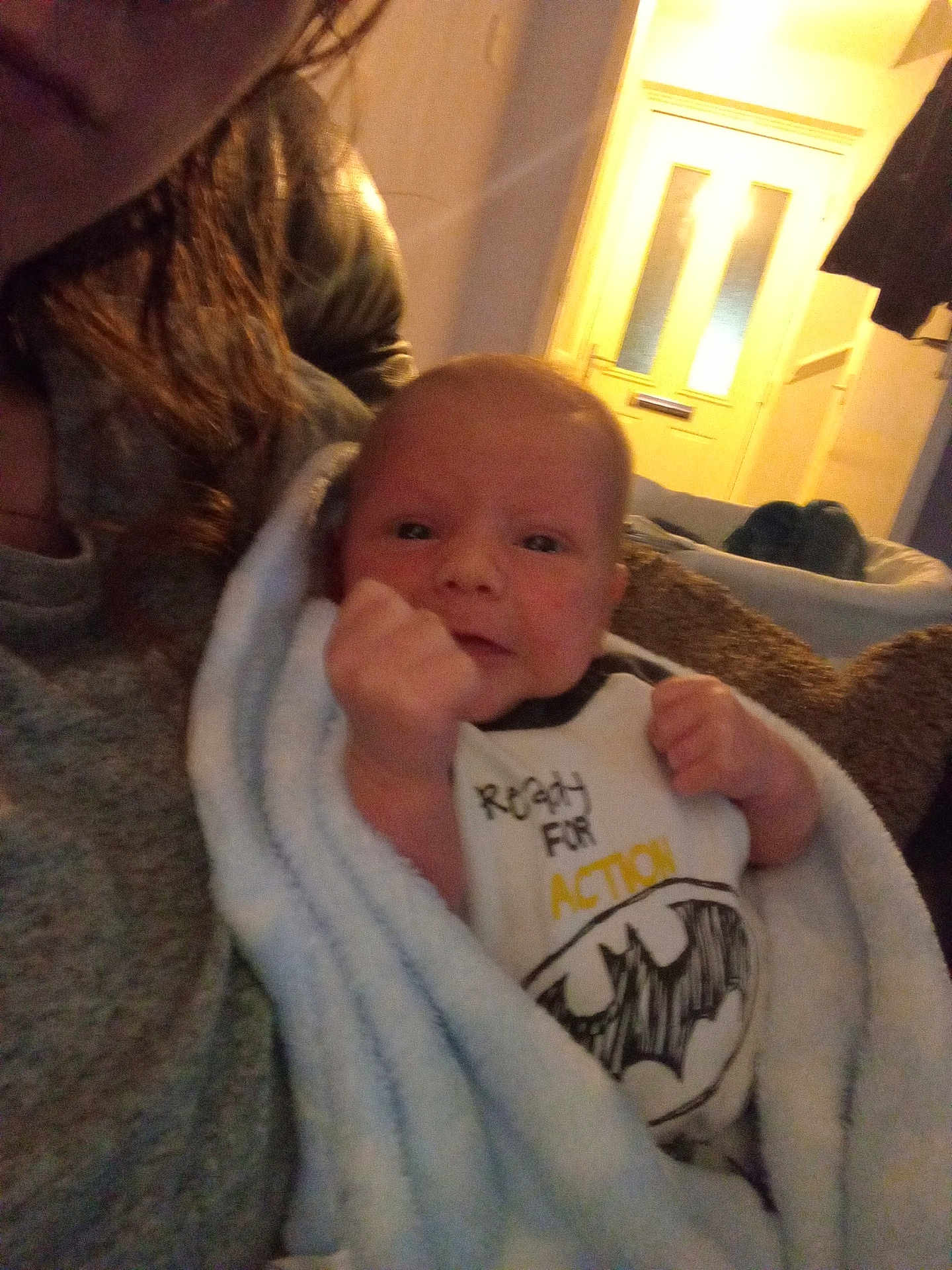 Leo joined the competition — help win amazing prizes! baby, blanket, batman_logo, clothing, face, hand, indoor, person, portrait, soft_lighting, toddler, warm_light, young_child, wrapped, couch, furniture, adult, hair, shirt, expression