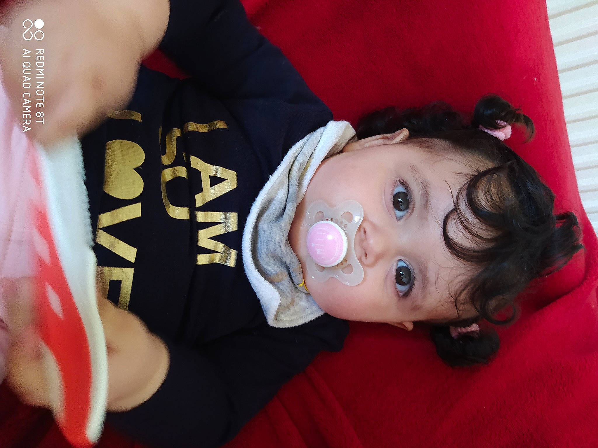 Lila a rejoint le concours — aidez-le/la à gagner de superbes lots ! arm, baby, baby_toddler_clothing, black_hair, cheek, child, elbow, eye, eyebrow, eyelash, fun, gesture, happy, joint, lip, neck, nose, person, pink, skin