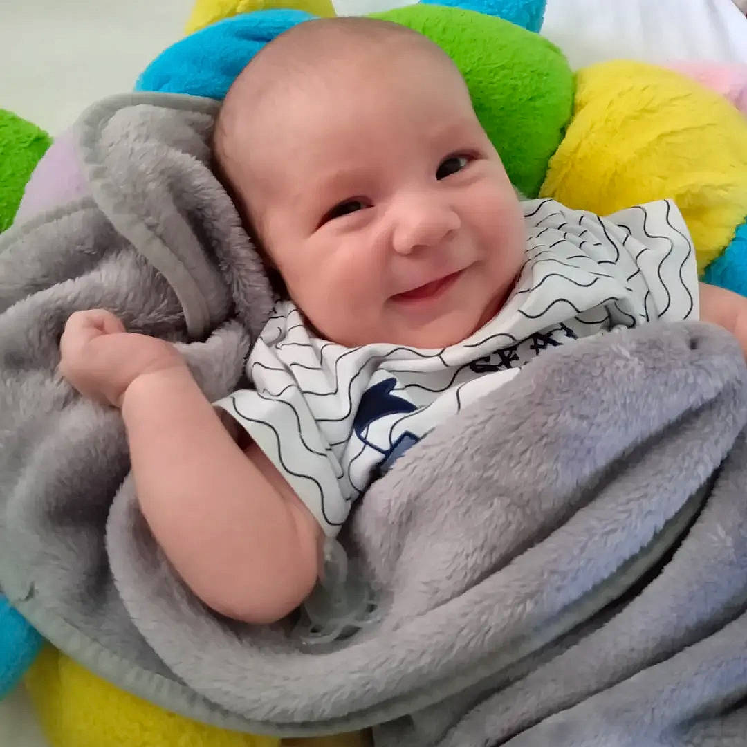 Emilio participe au concours pour gagner de l'argent avec cette photo : baby, baby_products, baby_sleeping, baby_toddler_clothing, cheek, child, chin, comfort, fun, happy, joy, linens, person, photograph, pink, sitting, skin, sleeve, smile, textile