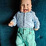 baby, baby_clothes, blue_shirt, casual, cheerful, child, clothing, couch, cute, fun, green_pants, happy, happy_face, indoor, infant, person, portrait, sitting, smiling, young_child