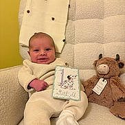 Felix joined the competition — help win amazing prizes! baby, infant, milestone_card, stuffed_animal, armchair, knitwear, smiling, cozy, indoor, soft_toys, plush, one_month, milestone, cute, child, face, person, blanket, yellow_wall, comfortable