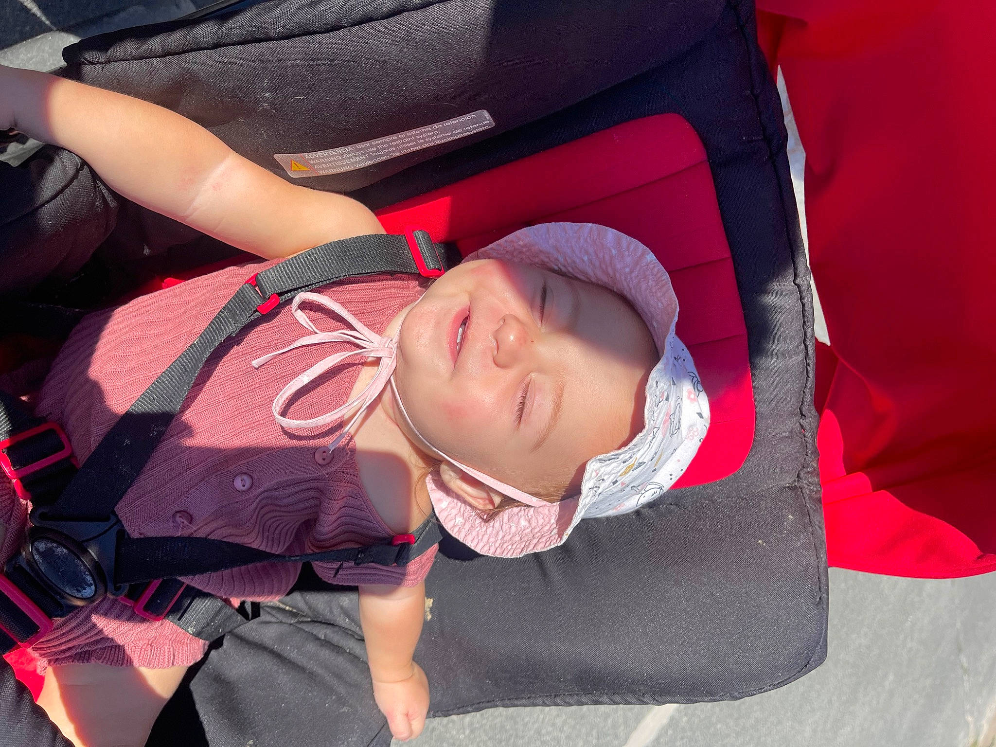 Kayla participe au concours pour gagner de l'argent avec cette photo : auto_part, baby_carriage, baby_products, backpack, bag, car_seat, carmine, child, comfort, fashion_accessory, fun, headwear, leisure, luggage_and_bags, magenta, mouth, person, personal_protective_equipment, pink, sitting