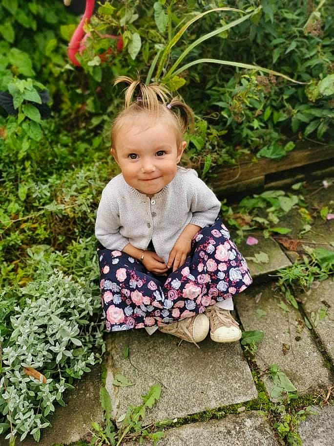 Myla participe au concours pour gagner de l'argent avec cette photo : baby, baby_toddler_clothing, botany, clothing, dress, face, flower, grass, green, groundcover, happy, joy, leaf, nature, people_in_nature, person, pink, plant, smile, terrestrial_plant