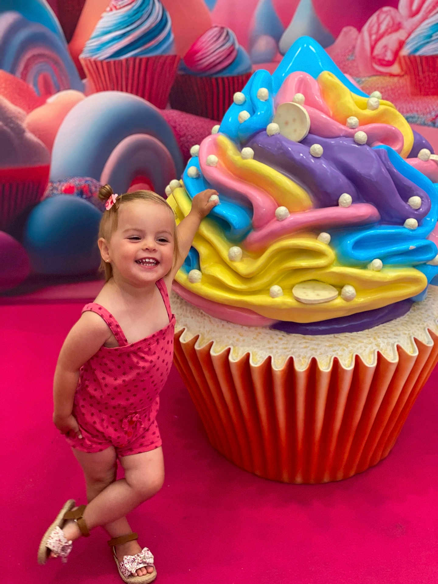 éléna participe au concours pour gagner de l'argent avec cette photo : toddler, child, smiling, pink_romper, sandal, cupcake, giant_cupcake, colorful, candy_theme, playful, posing, indoor, decor, toy, happy, background, sweet, fun, portrait, person