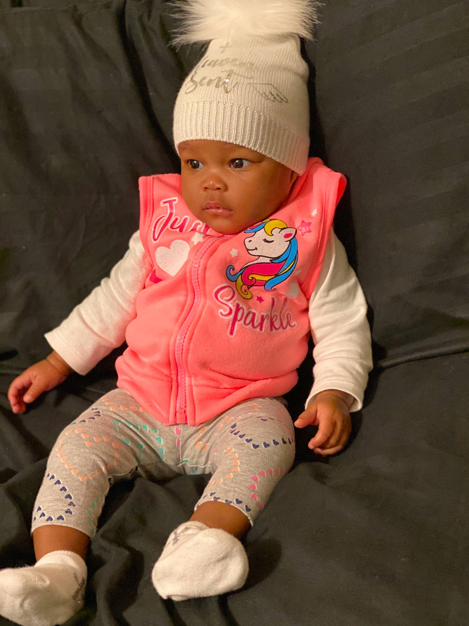 Jade joined the competition — help win amazing prizes! arm, baby, baby_toddler_clothing, cap, child, comfort, finger, hand, headwear, human_leg, knee, knit_cap, orange, person, personal_protective_equipment, pink, sitting, skin, sleeve, t_shirt