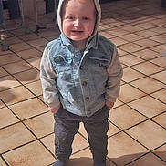 Noé a rejoint le concours — aidez-le/la à gagner de superbes lots ! baby, casual_clothing, child, clothing, cute, denim_jacket, floor_tiles, hands_in_pockets, hoodie, indoor, person, portrait, shadow, smiling, socks, standing, sunlight, tile_floor, toddler, young_child