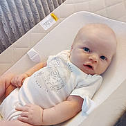 Peter is registered to the contest to win money with this photo: baby, infant, onesie, baby_seat, cushion, face, blue_eyes, hand, arm, leg, clothing, soft_lighting, indoor, cute, newborn, child, portrait, resting, fabric, comfort