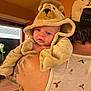baby, child, costume, lion, hood, animal_costume, cute, tattoo, shoulder, adult, person, indoors, window, warm_lighting, face, clothing, hat, portrait, expression, skin