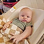 Peter is registered to the contest to win money with this photo: baby, blanket, baby_seat, indoor, person, infant, clothing, face, hand, cushion, fabric, red_bag, comfort, expression, pursed_lips, texture, resting, soft, home, cute