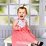 toddler, child, smiling, happy, dress, pink, floral, pony_tail, bench, shoes, black_shoes, indoor, floor, window, background, portrait, cute, sitting, person, studio