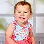 toddler, child, smiling, portrait, dress, floral_pattern, pink, hair_tie, ponytail, sitting, indoor, window, background, happy, cute, young, person, skin, face, hand