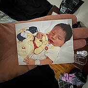 Waylon joined the competition — help win amazing prizes! hand, photo, baby, sleeping, clothing, winnie_the_pooh, infant, bed, room, floor, water_bottle, clothes, person, fingers, casual, indoor, portrait, relaxation, child, newborn