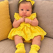 Adara Sanchez joined the competition — help win amazing prizes! baby, infant, child, portrait, sitting, couch, yellow_dress, yellow_bow, headband, socks, smiling, facial_expression, indoors, furniture, cushion, bracelet, earrings, fashion, closeup, photography