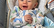 Jaxon joined the competition — help win amazing prizes! animal_print, baby, baby_accessory, baby_seat, blanket, blue, child, clothing, cozy, cute, floor, happy, indoor, infant, infant_care, onesie, person, portrait, smiling, wooden_floor