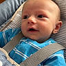 baby, child, blue_onesie, car_seat, seatbelt, indoor, infant, cute, face, head, clothing, straps, sitting, portrait, skin, eyes, expression, young, person, closeup