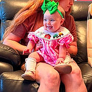 Macie joined the competition — help win amazing prizes! adult, baby, bib, child, farm_animals, green_bow, happy, headband, indoor, infant, lap, leather_couch, mother, pink_dress, portrait, shoes, smiling, socks, tractor, train