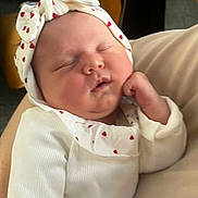 Agathe participe au concours pour gagner de l'argent avec cette photo : baby, sleeping, headband, white_clothing, heart_pattern, infant, cute, child, soft_lighting, portrait, resting, close_up, person, newborn, peaceful, toddler, human, hand, face, cozy