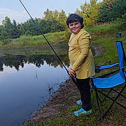 Malachi joined the competition — help win amazing prizes! blue_shoes, calm, chair, child, daylight, fishing_rod, grass, greenery, leisure, nature, outdoor, park, person, pond, recreation, reflection, smiling, trees, water, yellow_shirt