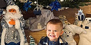 Sacha participe au concours pour gagner de l'argent avec cette photo : blue_clothing, child, christmas_tree, cute, decorations, festive, gnome, happy, holiday_decor, indoor, ornaments, plaid_jacket, plush_toys, polar_bear, portrait, santa_doll, seasonal, smiling, toddler, wooden_floor