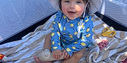 Olivia joined the competition — help win amazing prizes! baby, child, playpen, hat, blue_clothing, toy, stuffed_animal, striped_towel, smiling, sitting, indoors, mesh_sides, sunlight, shadow, play_area, infant, cute, happy, colorful, young