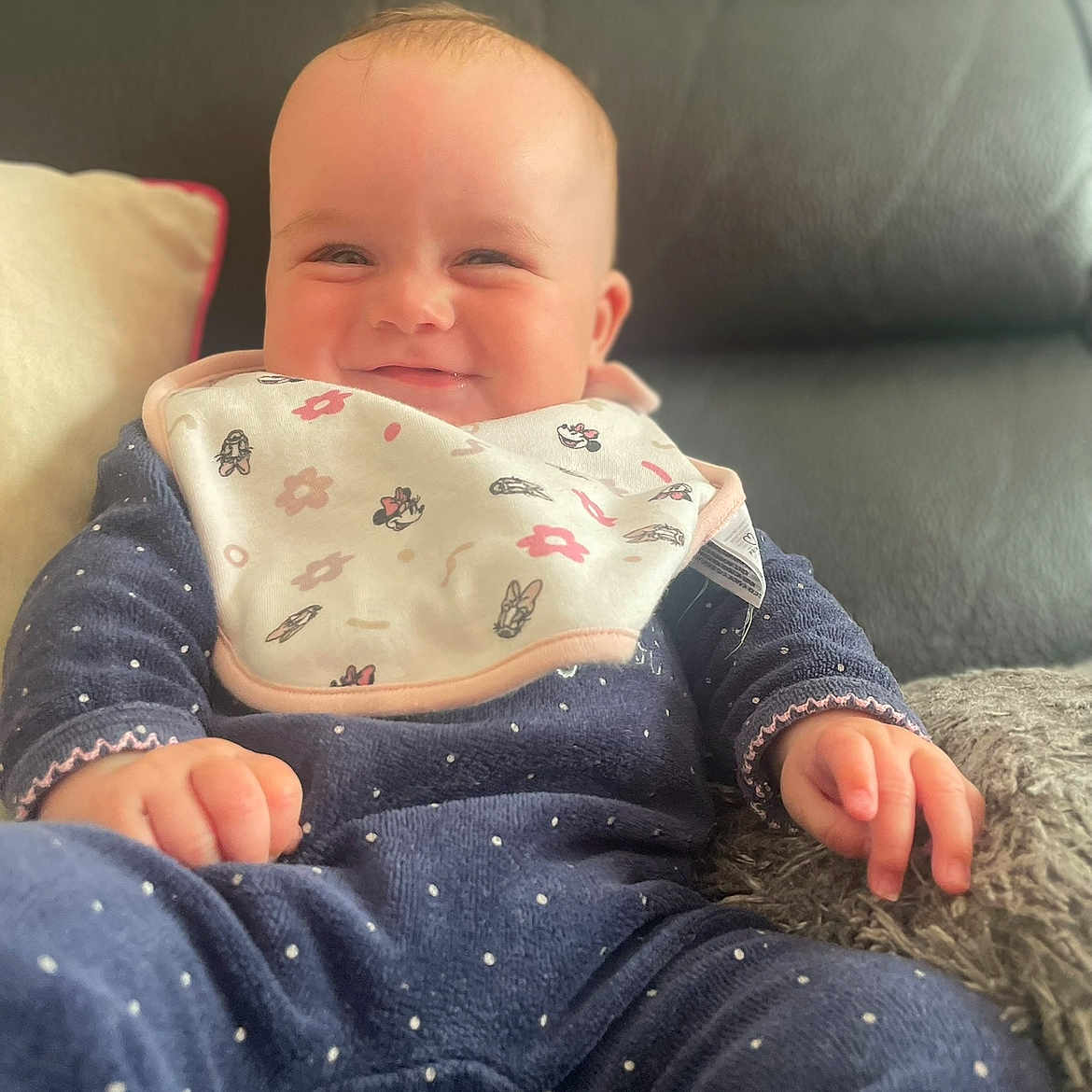 Mayana participe au concours pour gagner de l'argent avec cette photo : baby, bib, blue_clothing, child, couch, cozy, cute, face, hand, happy, indoors, infant, leather, pillow, polka_dot, portrait, relaxed, sitting, smile, young