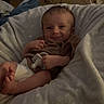 baby, infant, smiling, pacifier, cushion, blanket, brown_clothing, indoor, wooden_furniture, dresser, relaxed, comfort, soft_texture, child, person, face, happy, home, portrait, resting