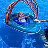 baby, blue, child, float, floating, fun, hand, infant, outdoor, person, pool, recreation, relaxing, summer, sunshade, support, swimming_pool, swimwear, vacation, water
