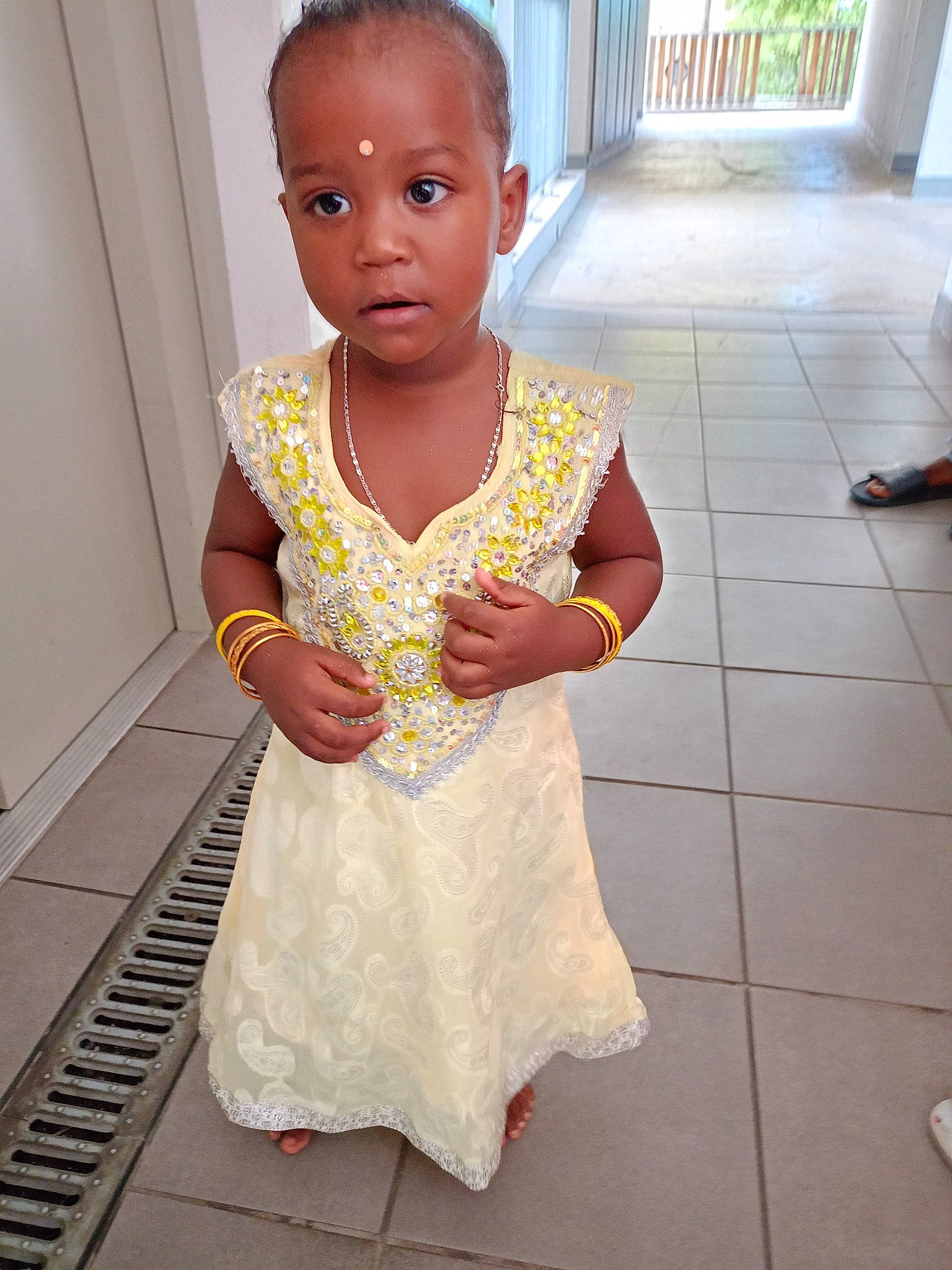 Kymberly participe au concours pour gagner de l'argent avec cette photo : baby_toddler_clothing, child, day_dress, dress, face, fashion_design, floor, flooring, gesture, happy, head, human_leg, magenta, neck, one_piece_garment, pattern, person, plant, sleeve, thumb