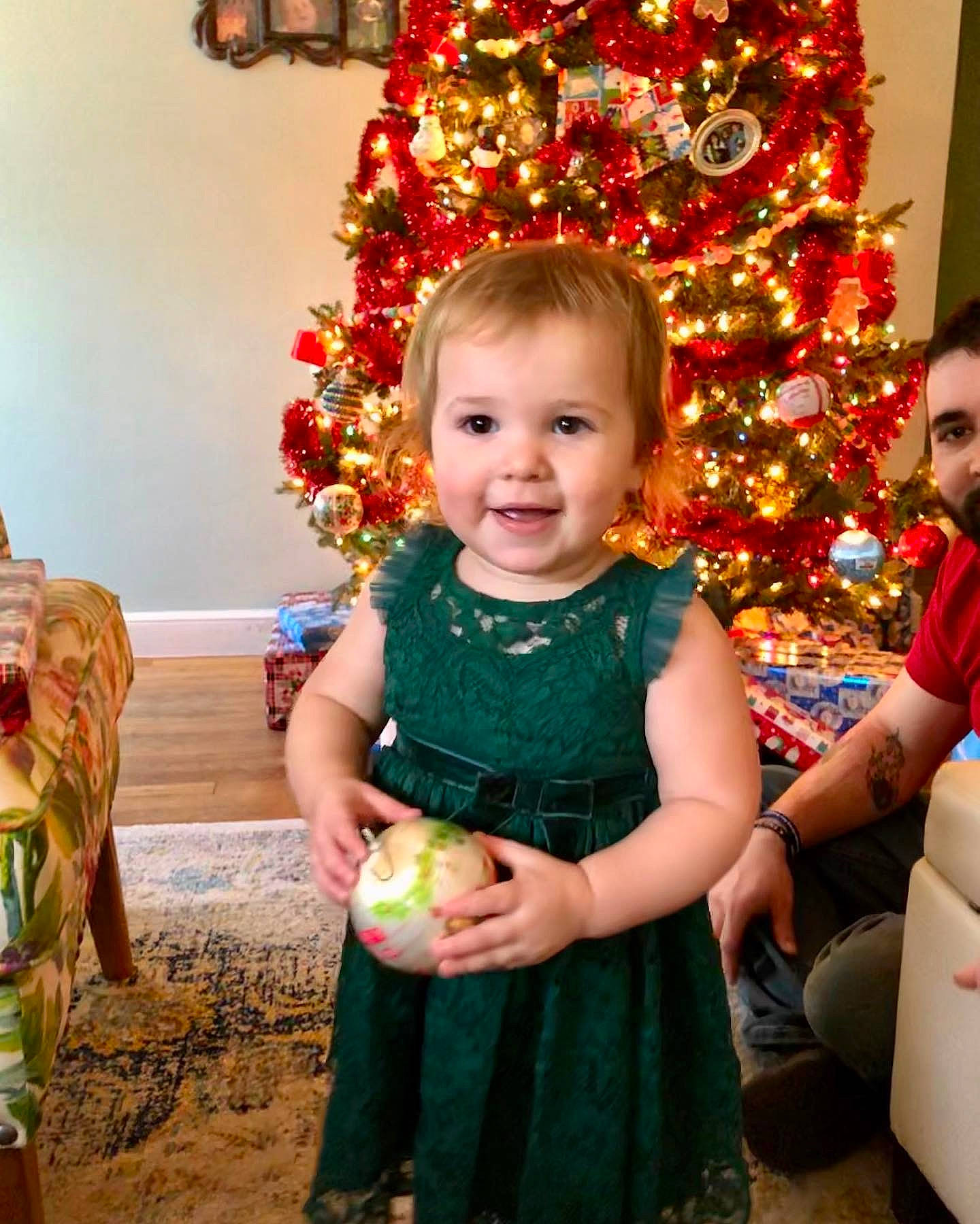 Kathryn is registered to the contest to win money with this photo: child, christmas, christmas_decoration, christmas_eve, christmas_lights, christmas_ornament, christmas_tree, event, family, happy, holiday, interior_design, person, smile, toddler, tradition, tree