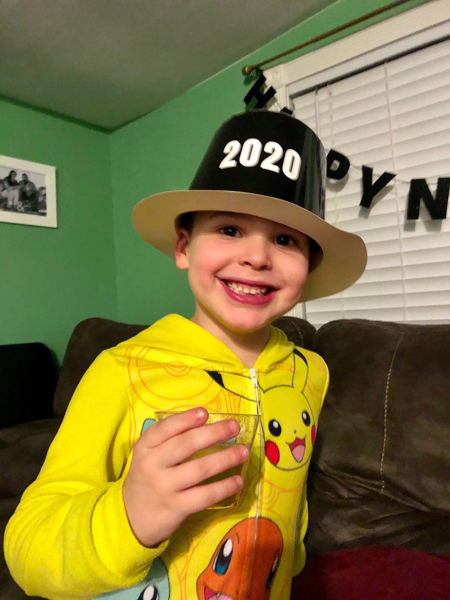Tommy is registered to the contest to win money with this photo: child, cool, fictional_character, hat, headgear, headwear, joy, person, smile, yellow