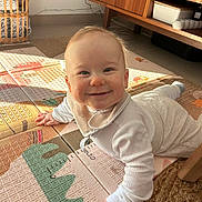 Thyam participe au concours pour gagner de l'argent avec cette photo : baby, bib, child, clothing, cozy, crawling, face, floor, hand, happy, head, home, indoor, infant, person, play_mat, smiling, sunlight, warm_light, wooden_furniture