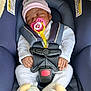 baby, infant, newborn, sleeping_baby, pacifier, pacifier_clip, pink_hat, car_seat, safety_harness, buckle, onesie, booties, hands, face, eyes_closed, cozy, seat_padding, warning_label, navy_blue, plush_canopy