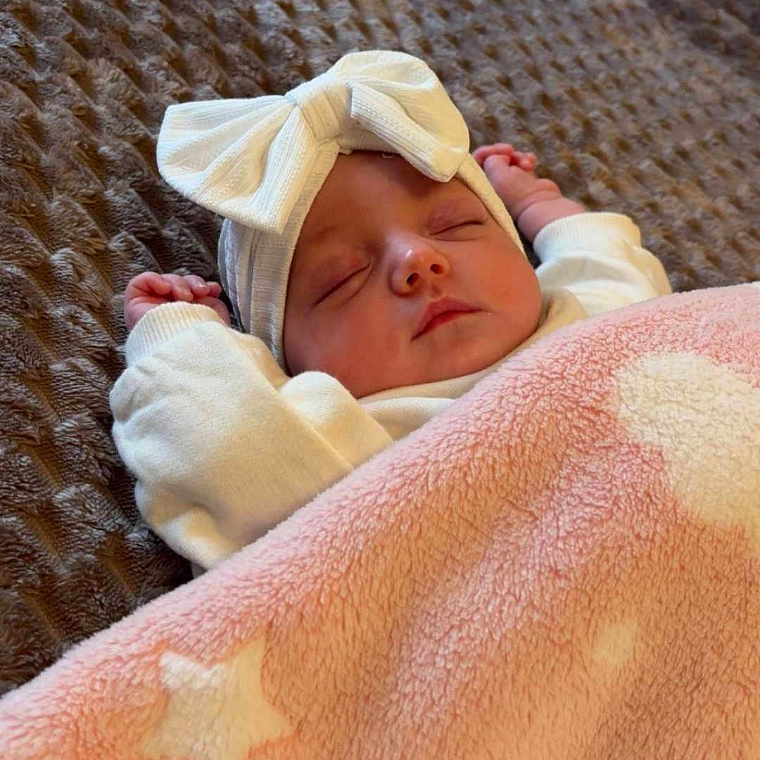Hayvie a rejoint le concours — aidez-le/la à gagner de superbes lots ! baby, blanket, bow, child, closeup, cozy, cute, face, headband, indoors, infant, peaceful, pink, resting, sleeping, soft_texture, star_pattern, warm, white, wrapped
