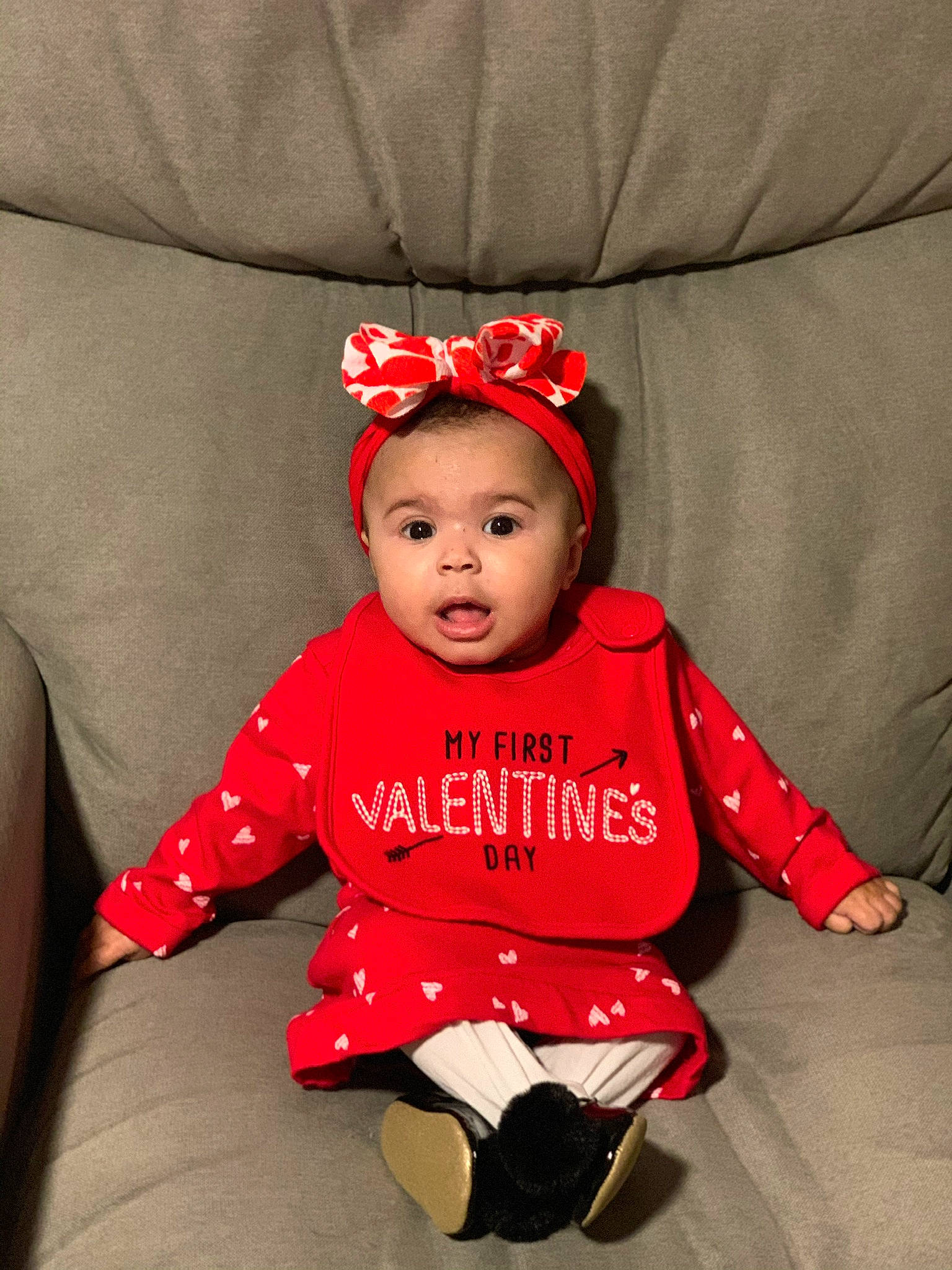 Kiyah is registered to the contest to win money with this photo: baby, baby_toddler_clothing, child, child_model, costume, hair_accessory, headgear, headpiece, person, photography, red, sitting, sleeve, surprise, toddler