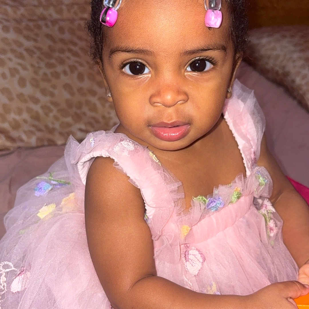 Anastassia is registered to the contest to win money with this photo: beads, blanket, child, curly_hair, cute, dress, embroidery, eyes, face, hand, holding, indoor, leopard_print, person, pink, portrait, sitting, toddler, wooden_wall, young_child