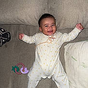 Aïtaynah a rejoint le concours — aidez-le/la à gagner de superbes lots ! baby, infant, smiling, onesie, pacifier, toy, couch, pillow, bamboo, happy, child, lying_down, indoors, cute, facial_expression, clothing, home, relaxed, baby_girl, baby_boy