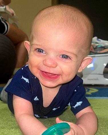 Brady is registered to the contest to win money with this photo: baby, baby_toddler_clothing, cheek, child, chin, ear, facial_expression, finger, flooring, fun, grass, hairstyle, happy, iris, joy, mouth, nose, person, skin, smile