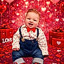 baby, balloon, bowtie, celebration, child, clothing, decoration, denim, gift, heart, indoor, love, pink, portrait, present, red, sitting, smiling, sneakers, valentine