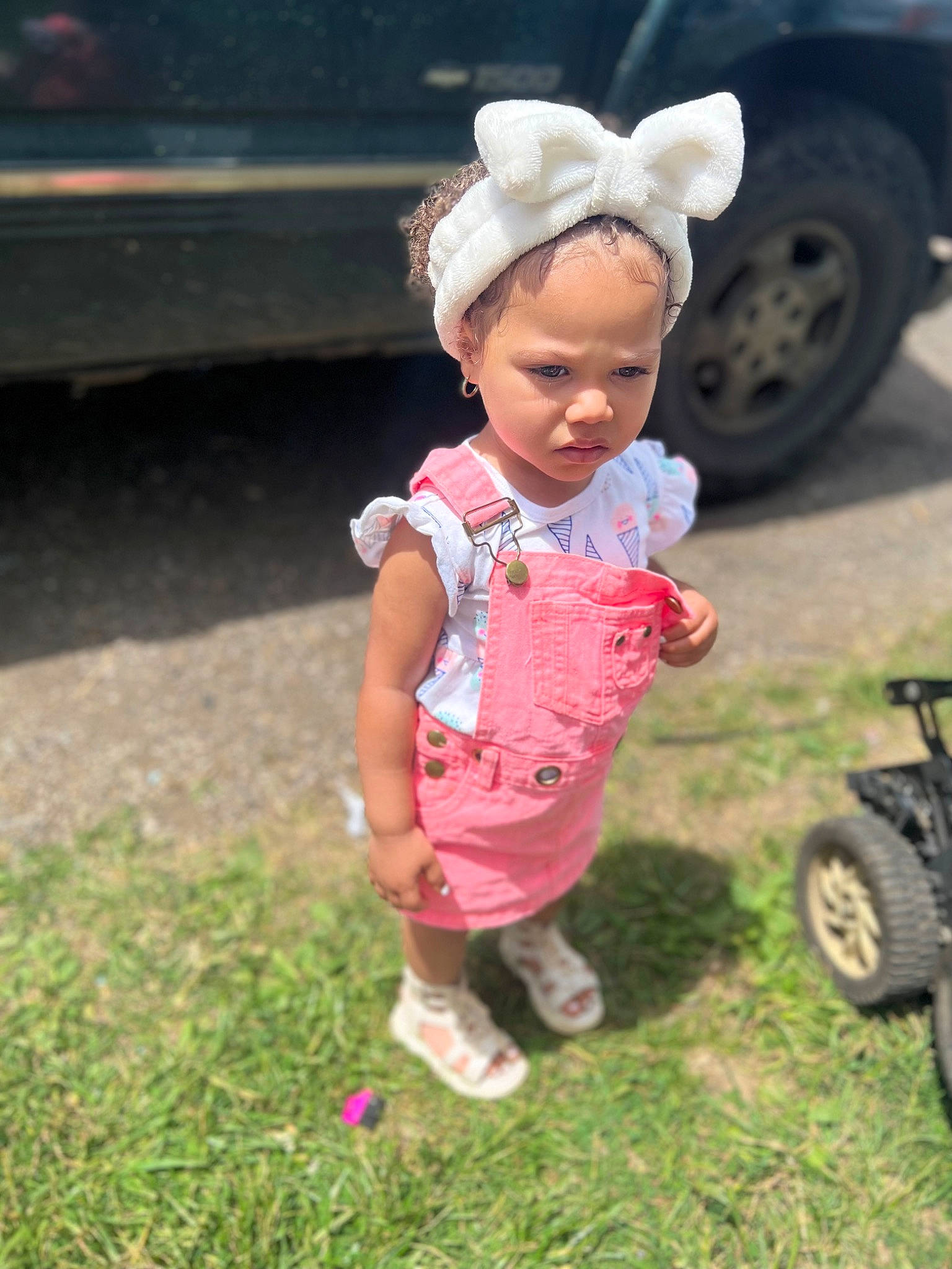 Diava is registered to the contest to win money with this photo: automotive_tire, baby_toddler_clothing, child, fun, garden, grass, grassland, happy, headwear, landscape, lawn, leisure, people_in_nature, person, plant, sandal, sitting, sneakers, soil, tire