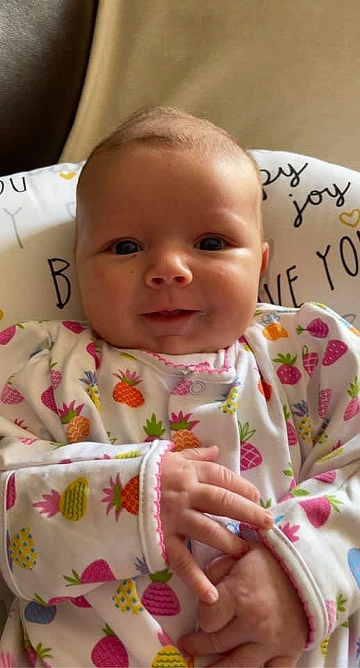 Laura is registered to the contest to win money with this photo: baby, baby_toddler_clothing, cheek, chin, face, facial_expression, finger, hand, happy, head, iris, lip, mouth, nose, person, pink, product, skin, sleeve, smile