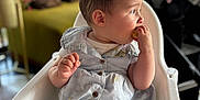 Lina participe au concours pour gagner de l'argent avec cette photo : baby, blurred_background, child, clothing, couch, curious, cute, daylight, eating, furniture, high_chair, home, indoor, infant, person, pillows, seated, short_sleeves, snack, stroller