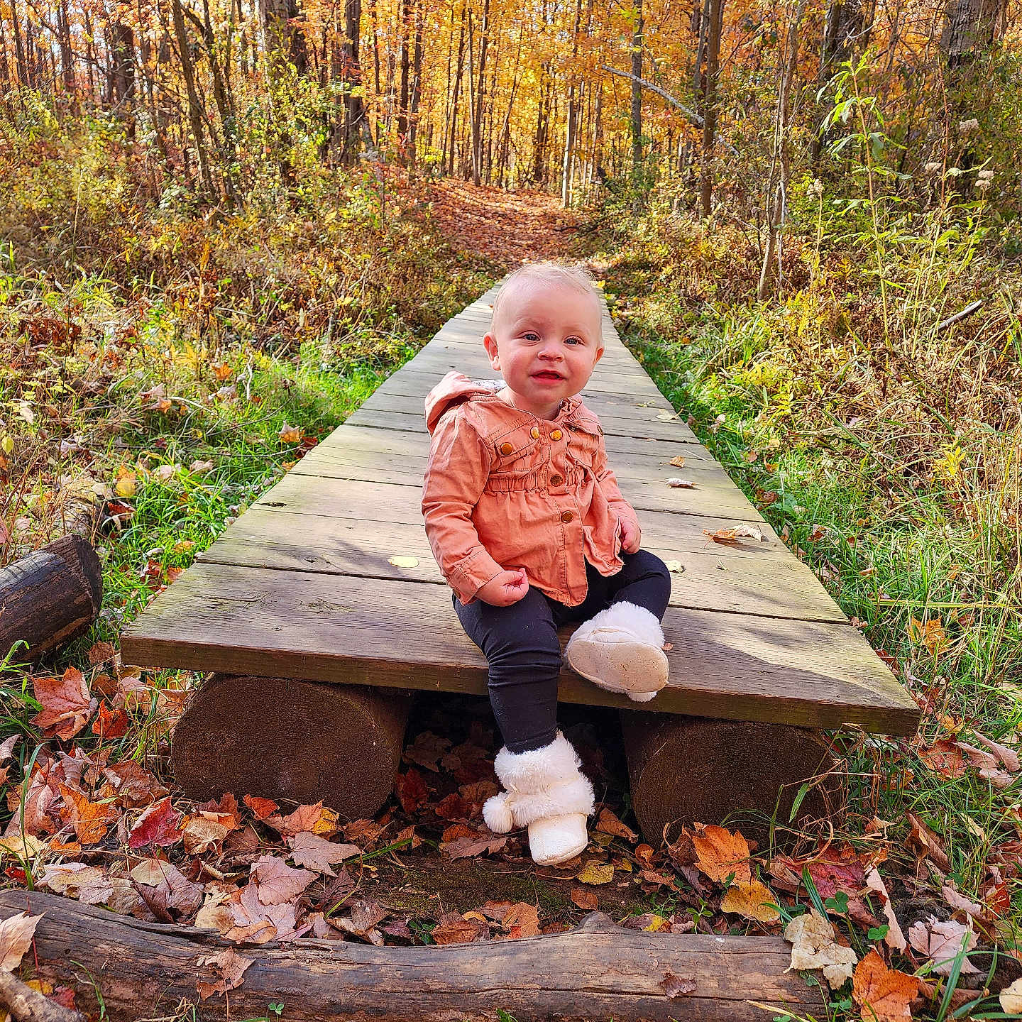 Emma is registered to the contest to win money with this photo: boardwalk, bridge, clothing, coat, face, grass, head, leaf, nature, outdoors, pants, path, person, photography, plant, portrait, trail, tree, vegetation, wood