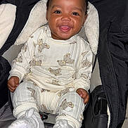 Ariana joined the competition — help win amazing prizes! baby, smile, pajamas, teddy_bear, stroller, footwear, happy, child, clothing, infant, cute, indoors, person, seat, cozy, warm, apparel, face, sitting, portrait