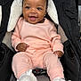 baby, infant, smiling, pink_clothing, knitwear, booties, stroller, black, gray, white_lining, happy, cute, child, portrait, seated, indoors, face, hands, feet, warm