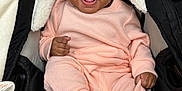 Ariana joined the competition — help win amazing prizes! baby, smiling, pink_clothing, knitwear, white_booties, stroller, black_stroller, fleece_lining, happy, infant, cute, child, seated, portrait, cozy, indoors, face, small_hands, footwear, warm