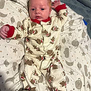 Cole is registered to the contest to win money with this photo: baby, infant, onesie, monkey_pattern, blanket, stars, moon, planets, lying_down, cute, sleepwear, footed_pajamas, bedroom, soft_toys, child, newborn, portrait, indoor, cozy, curious