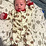 baby, infant, onesie, monkey_pattern, blanket, stars, moon, planets, lying_down, cute, sleepwear, footed_pajamas, bedroom, soft_toys, child, newborn, portrait, indoor, cozy, curious