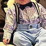 baby, child, smile, plaid_shirt, bow_tie, suspenders, blue_pants, sitting, indoor, cute, happy, infant, clothing, footwear, person, portrait, red_hair, toddler, carpet, hand