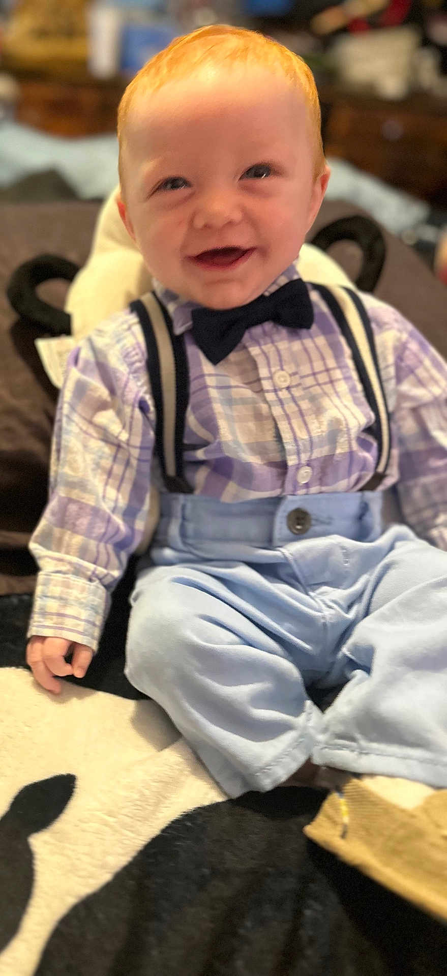 Cole joined the competition — help win amazing prizes! baby, child, smile, plaid_shirt, bow_tie, suspenders, blue_pants, sitting, indoor, cute, happy, infant, clothing, footwear, person, portrait, red_hair, toddler, carpet, hand