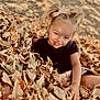child, smiling, autumn, leaves, outdoor, nature, playful, pigtails, dirt, fall, happy, grass, season, person, cute, young, fun, park, casual, portrait